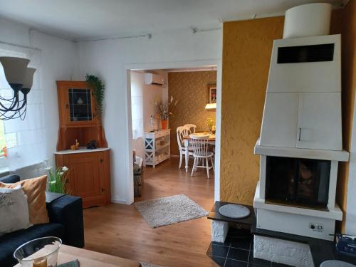 a living room with a fireplace and a kitchen at Ferienhaus Heidi in Rosenfors