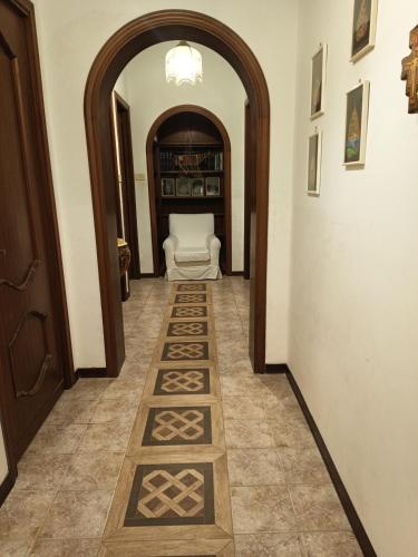 a hallway with an archway with a white chair in a room at Adelia House in Catania