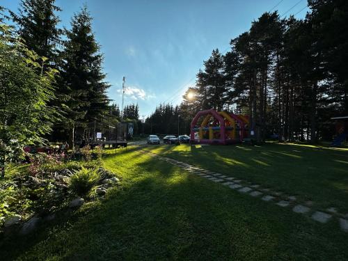 a yard with a playground with cars parked in it at Парк-хотел Родопи in Churen