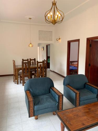 a living room with two chairs and a table at Carmel Crown Villa in Hatton