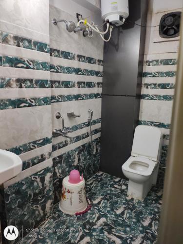 een badkamer met toilet en een taart op de vloer bij Hotel Vikrant in Deoghar