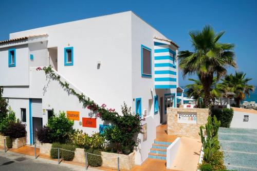 a white building with a palm tree in front of it at Piccolo Grand Hotel in Pizzo