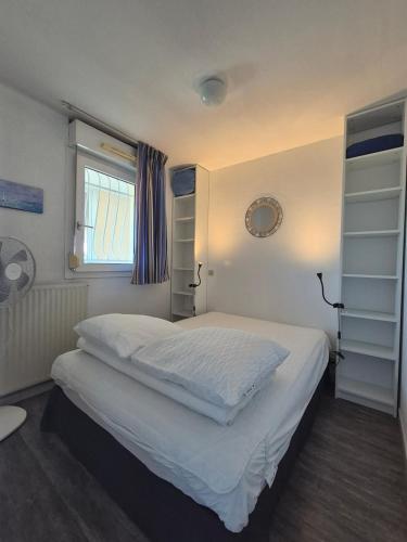 une chambre avec un lit avec des draps blancs et une fenêtre dans l'établissement Chez Laurette, à Balaruc-les-Bains