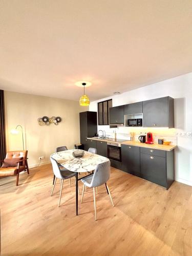 une cuisine et une salle à manger avec une table et des chaises dans l'établissement Urban Chic, à Montélimar