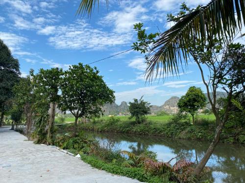a river with trees on the side of a road at Tam Coc Moutainside Homestay in Ninh Binh