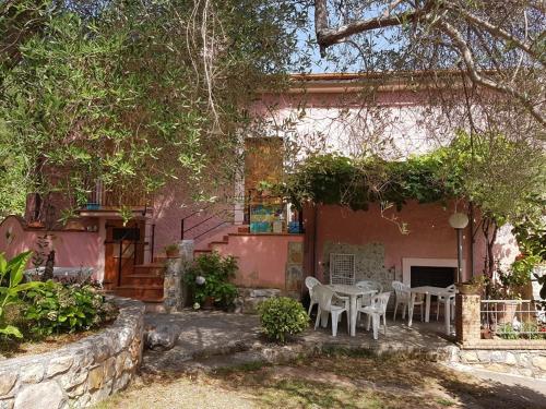 a house with a table and chairs in front of it at B&B IL VECCHIO GELSO in Palinuro