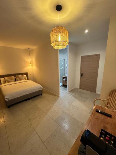 a bedroom with a bed and a chandelier at 27 côté remparts in Aigues-Mortes