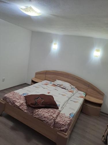 a bed in a room with two lights on the wall at Cabana cosmina și milan in Arieşeni