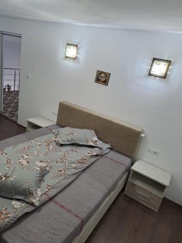 a bedroom with a bed and two lights on the wall at Cabana cosmina și milan in Arieşeni