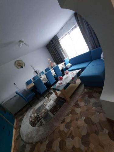 a living room with a blue couch and a table at Cabana cosmina și milan in Arieşeni