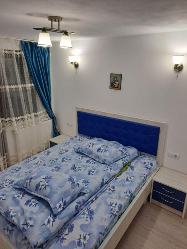 a bed in a bedroom with a blue bedspread at Cabana cosmina și milan in Arieşeni