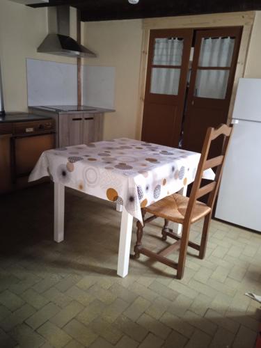 La cuisine est équipée d'une table, de deux chaises et d'un réfrigérateur. dans l'établissement gite de la via ferrata liaucous, à Mostuéjouls