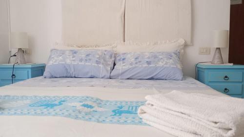 a bedroom with a bed with two blue night stands at B&B Guest House Il Porto Vecchio in Stintino