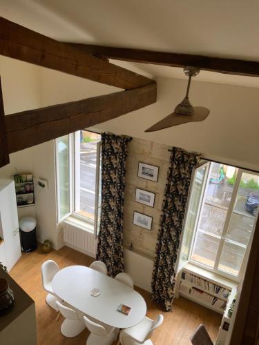 une salle à manger avec une table, des chaises et des fenêtres dans l'établissement T2 spacieux et lumineux Bordeaux centre, à Bordeaux
