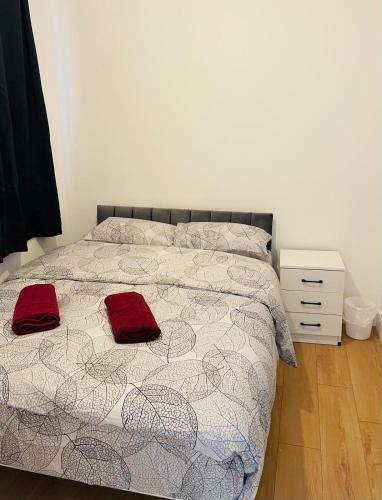 a bedroom with a bed with two red pillows on it at OYO Dorset House at Upton Park in London