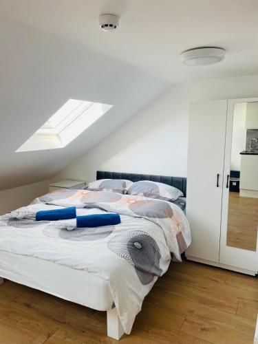 a white bedroom with a bed with a skylight at OYO Dorset House at Upton Park in London
