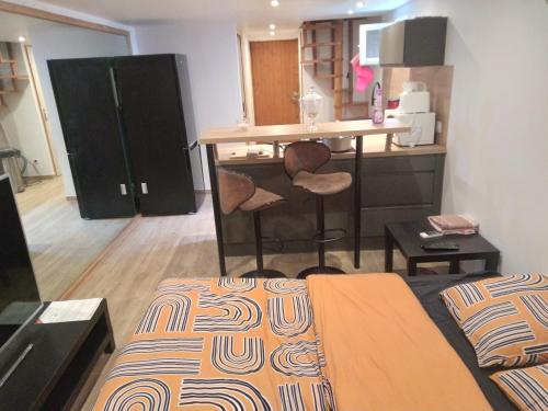 a room with a bed and a kitchen with a counter at Studio avez mezzanine et petit jardin in Montélimar