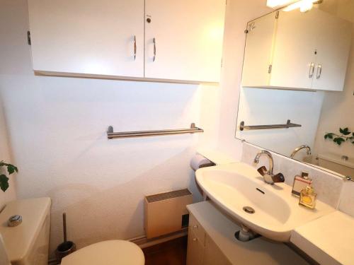 une salle de bain avec un lavabo, des toilettes et un miroir dans l'établissement Studio Cabine avec Piscines, Parking, Proche Mer et Commerces - FR-1-307-61, au Grau-du-Roi