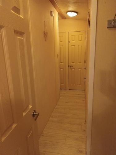 a hallway with white doors and wood floors at 3 bed 2 bath Static on parkdean morecambe in Morecambe
