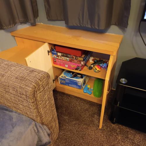 a small wooden table next to a bed at 3 bed 2 bath Static on parkdean morecambe in Morecambe