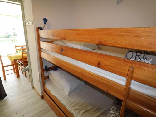 Ce lit superposé en bois se trouve dans un dortoir. dans l'établissement Studio cabine, terrasse au Grau-du-Roi, proche plage et commerces - FR-1-307-96, au Grau-du-Roi