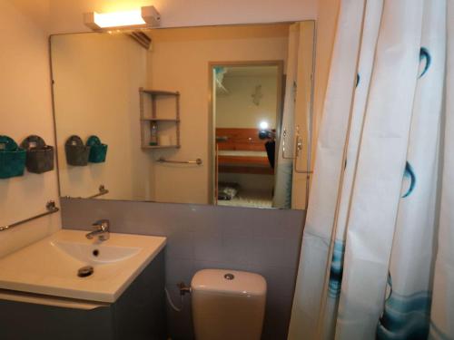 une salle de bain avec un lavabo, des toilettes et un miroir dans l'établissement Studio cabine, terrasse au Grau-du-Roi, proche plage et commerces - FR-1-307-96, au Grau-du-Roi