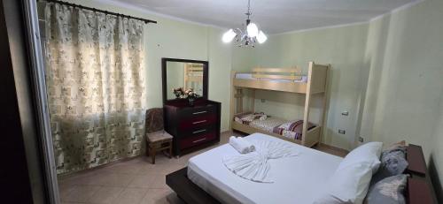 ヴロラにあるApartment me qera Lungomare Vlore Dejvid by the seaのベッドとドレッサーと鏡のある寝室