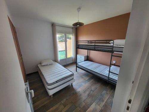 une chambre avec deux lits superposés et une fenêtre dans l'établissement SP000-017B Appartement 3 pièces - jusqu'à 5 personnes - Saint Pierre la mer, à Saint Pierre La Mer