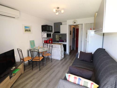 un salon avec un canapé et une table et une cuisine dans l'établissement Studio cabine climatisé, proche plage, parfait pour 4 pers. - FR-1-307-123, au Grau-du-Roi