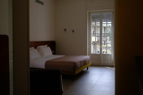 a bedroom with a bed and a window and a door at Le Stanze del Lago Suites & Pool in Como
