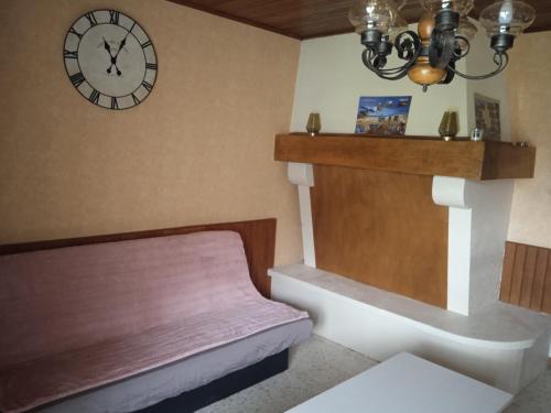 une chambre avec un banc et une horloge sur le mur dans l'établissement gite de la via ferrata liaucous, à Mostuéjouls