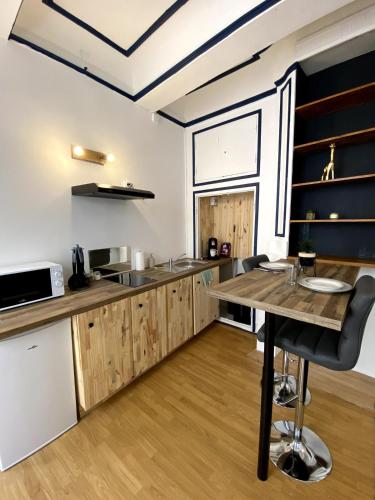 une cuisine avec des armoires en bois et une table en bois dans l'établissement Loft au coeur du centre historique, à Narbonne
