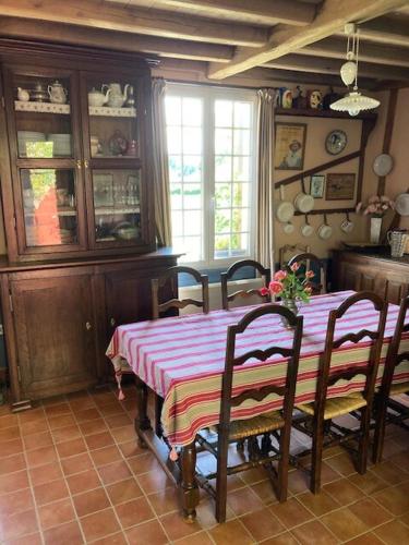 une salle à manger avec une table et des chaises et une fenêtre dans l'établissement Rose des prés, à Maisnières