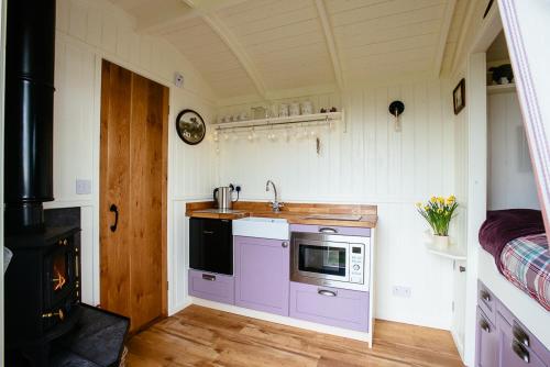 a kitchen with a microwave and a stove in it at Crown Cottage Farm in Skipton