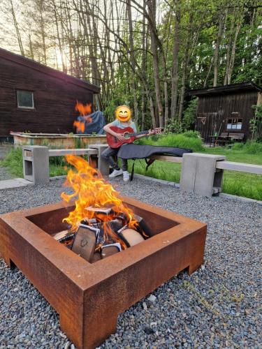 a fire pit with a person sitting on a bench at Weiherhüttla in Untersteinach