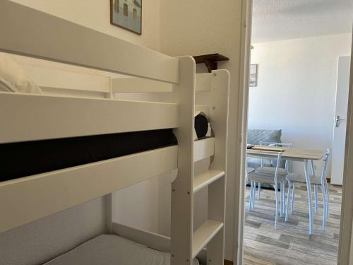 Ce lit superposé se trouve dans un dortoir doté d'une table. dans l'établissement Appartement à 50m de la plage, 6 couchages - FR-1-229D-147, à Fleury