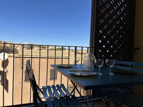 - une table avec des verres à vin au-dessus du balcon dans l'établissement Appartement à 50m de la plage, 6 couchages - FR-1-229D-147, à Fleury