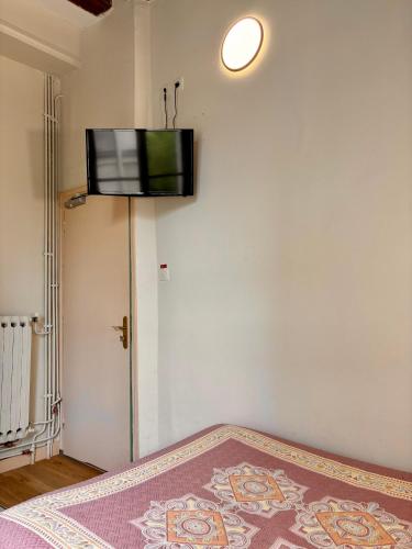 Cette chambre dispose d'une télévision murale à écran plat. dans l'établissement Hôtel Des Fontaines, à Paris