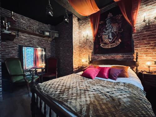 a bedroom with a large bed in a brick wall at Harry Potter L'expérience, Nuit Magique à Poudlard in Sedan