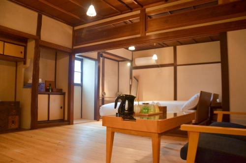 Habitación con cama, mesa y teléfono. en 篠山城下町ゲストハウス inosica, en Tamba-sasayama