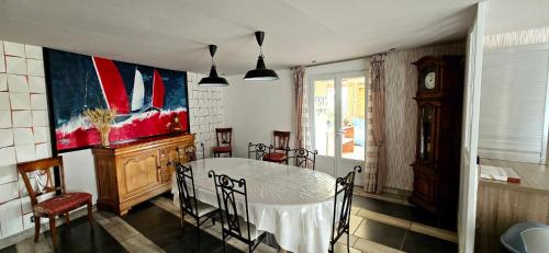 une salle à manger avec une table, des chaises et une horloge dans l'établissement Gites de la Meitairie, à Bignan