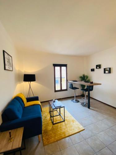 un salon avec un canapé bleu et une table dans l'établissement Logement coeur de ville, à Narbonne
