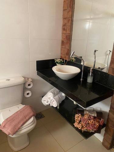 a bathroom with a sink and a toilet at Pousada Rural Vista do Limoeiro in Itabira