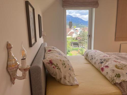 a bedroom with a bed with pillows and a window at Villa Bella Vita in Seeboden