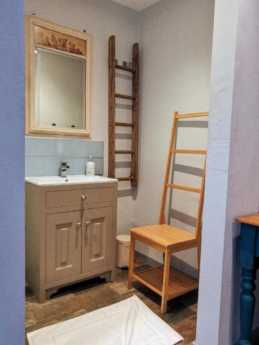 a bathroom with a sink and a wooden chair at the Nook, Romantic cottage for two, Dartmoor and SW coast in Bovey Tracey