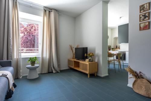 a bedroom with a blue tile floor and a television at Botanical by Tss - Nuovo, in centro, 10 min lago in Caldonazzo
