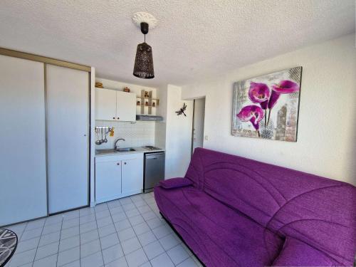 - un canapé violet dans une chambre avec cuisine dans l'établissement Appartement 2 pièces avec piscine, parking privé et accès direct à la plage - FR-1-387-50, à Marseillan