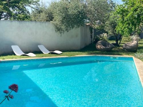- une piscine avec 2 chaises longues dans la cour dans l'établissement Village house with pool 8 minutes from Uzès, à Flaux