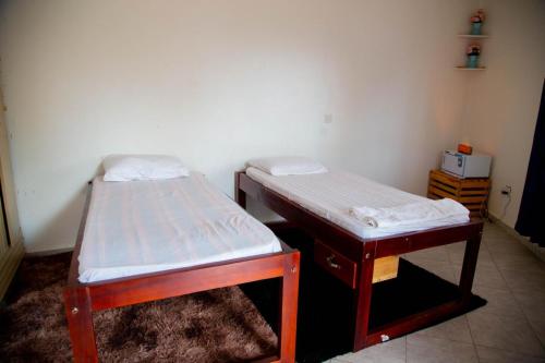 a pair of twin beds in a room at Noaz Hotel in Bulambiro