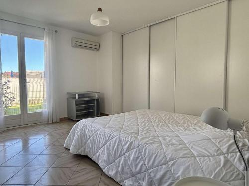 une chambre avec un lit blanc et une fenêtre dans l'établissement Élégant T2 avec Jardin, Secteur Calme, Proche Mer et Commerces - Latour-Bas-Elne - FR-1-225-650, à Latour-Bas-Elne